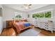 Sunlit main bedroom featuring hardwood floors, a ceiling fan, and scenic views from the large windows at 721 Park Ln, Lakewood, CO 80214