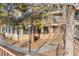 Inviting exterior of home showcasing maintained landscaping, mature trees and a second story deck at 980 S Dahlia St # A, Denver, CO 80246