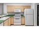 Kitchen with white appliances, natural wood cabinets, and adjacent laundry unit at 980 S Dahlia St # A, Denver, CO 80246