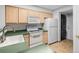 Kitchen with white appliances, natural wood cabinets, and adjacent laundry unit at 980 S Dahlia St # A, Denver, CO 80246