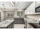 Bright kitchen showcases granite counters, stainless steel appliances, grey cabinets and tile floors at 10172 Woodrose Ln, Highlands Ranch, CO 80129