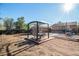 Backyard featuring a pergola over a patio set in a garden with some playground equipment in the distance at 7066 Jennie Dr, Denver, CO 80221