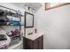 Small bathroom with a vanity sink, basic mirror, metal shelving, and a toilet at 7066 Jennie Dr, Denver, CO 80221