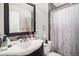 Bathroom featuring a single sink, decorative backsplash, a large mirror, and a shower with patterned curtain at 7066 Jennie Dr, Denver, CO 80221