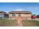 Charming single-story brick home featuring a well-maintained front lawn, pathway, and new roof at 7066 Jennie Dr, Denver, CO 80221
