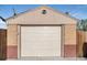 Exterior of a one car garage with a white door and tan and brick exterior walls at 7066 Jennie Dr, Denver, CO 80221
