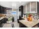 Modern kitchen featuring stainless steel appliances, granite countertops, breakfast bar, and dark cabinets at 7066 Jennie Dr, Denver, CO 80221