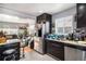 Modern kitchen featuring stainless steel appliances, granite countertops, dark cabinetry, and tile floors at 7066 Jennie Dr, Denver, CO 80221