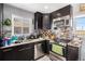 Well-equipped kitchen featuring modern appliances, granite countertops, wine rack, and dark cabinets at 7066 Jennie Dr, Denver, CO 80221