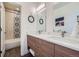 Bathroom with a double sink vanity with modern fixtures, decorative mirrors, and decorative tile accent wall in bath at 4795 Highline Pl, Denver, CO 80222