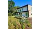 Contemporary home featuring a manicured lawn, colorful garden, and inviting front patio at 4795 Highline Pl, Denver, CO 80222