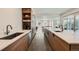 Contemporary kitchen boasts a spacious island with a sink, wood cabinetry, and stainless steel appliances at 4795 Highline Pl, Denver, CO 80222