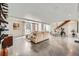 Bright open-concept living space with a modern staircase and sleek concrete floors at 4795 Highline Pl, Denver, CO 80222