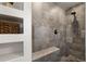 Walk-in shower with gray tile and built-in seat at 16530 Timber Cove St, Hudson, CO 80642