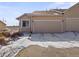 Exterior view of a townhome with an attached garage and snowy landscaping in a suburban neighborhood at 12292 E 2Nd Dr, Aurora, CO 80011