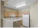 Compact kitchen featuring white appliances and light wood cabinetry at 12292 E 2Nd Dr, Aurora, CO 80011