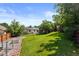 Expansive backyard featuring a lush lawn, mature trees, and solar panels on the home's roof at 4627 S Norfolk Way, Aurora, CO 80015