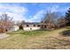 Spacious backyard with lush green grass, mature trees, and solar panels on roof at 4627 S Norfolk Way, Aurora, CO 80015