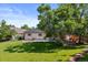 Expansive backyard featuring a lush lawn, mature trees, and solar panels on the home's roof at 4627 S Norfolk Way, Aurora, CO 80015
