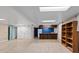 Finished basement featuring tile and carpet flooring with bar and shelving at 4627 S Norfolk Way, Aurora, CO 80015
