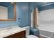 Charming bathroom with wood-look vanity, framed mirror, and bathtub with shower at 4627 S Norfolk Way, Aurora, CO 80015
