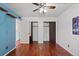 Bedroom featuring hardwood floors, a ceiling fan, and closet space at 4627 S Norfolk Way, Aurora, CO 80015
