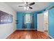 Bright bedroom with hardwood floors, ceiling fan, and blue accent wall at 4627 S Norfolk Way, Aurora, CO 80015