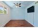 Bright bedroom featuring warm hardwood floors, ceiling fan, and flat screen TV at 4627 S Norfolk Way, Aurora, CO 80015