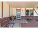 Charming covered front porch with brick accents, featuring a cozy outdoor seating area at 4627 S Norfolk Way, Aurora, CO 80015