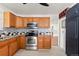 Well-lit kitchen with wood cabinetry, granite countertops, and stainless steel appliances at 4627 S Norfolk Way, Aurora, CO 80015