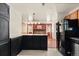 Modern kitchen with an island and black appliances, with views into the living room at 4627 S Norfolk Way, Aurora, CO 80015
