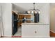 Open kitchen area with a breakfast bar, black refrigerator, wood cabinets, and modern backsplash at 4627 S Norfolk Way, Aurora, CO 80015
