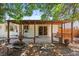 Back patio with seating, fire pit, mature shade trees, and access to the home's interior at 4627 S Norfolk Way, Aurora, CO 80015