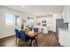 Bright dining area with a wooden table, blue chairs, and a view of the modern kitchen at 5805 Red Barn Ave, Longmont, CO 80504