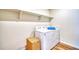 Functional laundry room with a washing machine, dryer, and open shelving for storage at 5805 Red Barn Ave, Longmont, CO 80504
