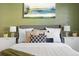 Cozy bedroom with gray headboard, white bedding, and olive green accent wall at 670 S Oswego St, Aurora, CO 80012