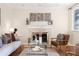 Spacious living room with a fireplace, hardwood floors, and mid-century modern furniture at 670 S Oswego St, Aurora, CO 80012