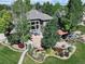 An aerial view of a beautiful home with mature trees, landscaping, gazebo, and a lovely backyard water feature at 6940 Saddleback Ave, Firestone, CO 80504
