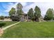 Expansive backyard featuring a lush lawn, mature trees, and a patio perfect for outdoor entertaining at 6940 Saddleback Ave, Firestone, CO 80504