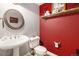 Comfortable powder room with pedestal sink, toilet, and rustic decor at 6940 Saddleback Ave, Firestone, CO 80504