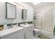 Bright bathroom with dual vanities, a skylight, and a shower with glass doors at 6940 Saddleback Ave, Firestone, CO 80504