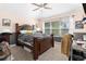 Bedroom with a ceiling fan, large window, and neutral carpet flooring at 6940 Saddleback Ave, Firestone, CO 80504