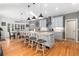 Bright, open kitchen with island including bar stool seating, light blue cabinets, and stainless steel appliances at 6940 Saddleback Ave, Firestone, CO 80504