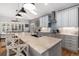 Bright, open kitchen with island including bar stool seating, light blue cabinets, and stainless steel appliances at 6940 Saddleback Ave, Firestone, CO 80504