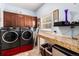 Practical laundry room with washer, dryer, folding table, and storage at 6940 Saddleback Ave, Firestone, CO 80504
