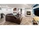Spacious living room with a cozy fireplace, comfortable seating, and wood flooring at 6940 Saddleback Ave, Firestone, CO 80504
