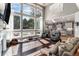 Bright living room with floor-to-ceiling windows, hardwood floors, and comfortable seating area at 6940 Saddleback Ave, Firestone, CO 80504