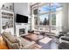 Inviting living room with large windows, a fireplace, hardwood floors, and built-in shelving at 6940 Saddleback Ave, Firestone, CO 80504