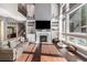 Spacious living room featuring a fireplace, large windows, hardwood floors, and a comfortable sofa at 6940 Saddleback Ave, Firestone, CO 80504