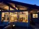 Home exterior featuring large windows with living room and kitchen views at dusk at 21437 Alta Dr, Morrison, CO 80465